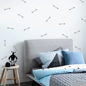 Detail view of gray arrow wall decals in a Nordic minimalist style on a bedroom wall