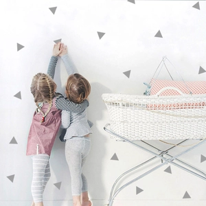 Detailed view of matte grey triangle wall stickers in a minimalist Nordic nursery decor