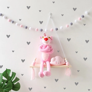 Detail view of heart wall stickers with wooden shelf and pink decorative tassels