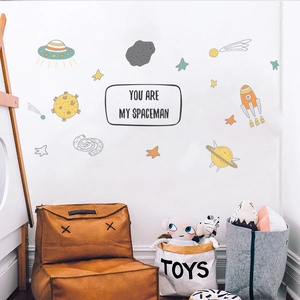 Detailed space wall decals featuring UFOs and planets over a cozy child playroom sofa