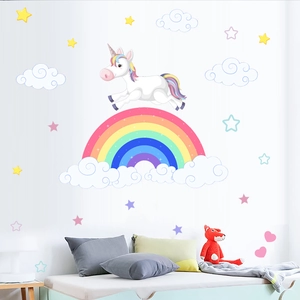 Detail view of colorful unicorn and rainbow wall decals on a cozy kid bedroom wall