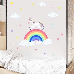 Detailed view of cartoon unicorn and rainbow wall decals in a cozy nursery room setting