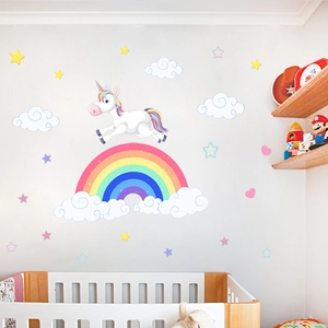 Detail view of cartoon unicorn and rainbow wall decals in a cozy children's nursery room