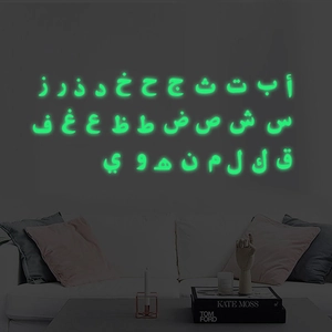 Luminous Arabic alphabet wall stickers glowing green in a modern living room setting