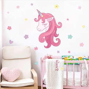 Detail showing a pink unicorn head wall sticker with floral and star elements in a nursery