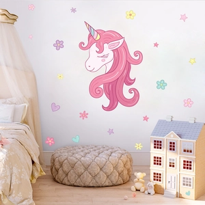 Detail of pink unicorn wall stickers with stars and hearts in a cozy nursery room decor
