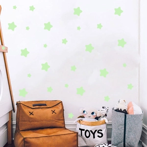 Detailed view of luminous star wall stickers in various sizes on a white bedroom wall