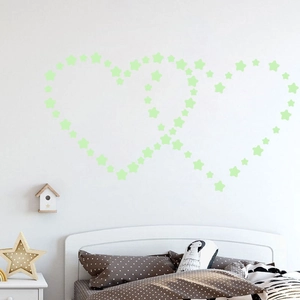 Luminous star stickers arranged in a double heart shape on a bedroom wall background