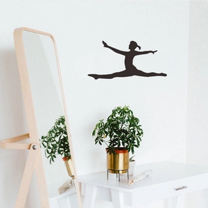 Black silhouette wall decal of a ballet dancer leaping above a white hallway cabinet