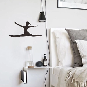 Detail of black silhouette wall sticker showing a graceful gymnast leaping on a white wall