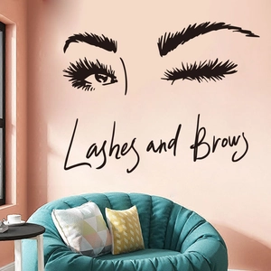 Black Lashes and Brows wall decal with closed eyes on a pink wall above a modern sofa