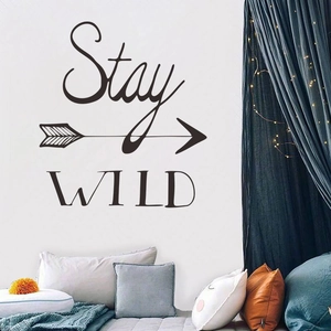 Stay Wild arrow wall decal in a cozy bedroom setting with decorative pillows
