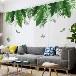Détail de stickers muraux feuilles tropicales avec bananiers et palmiers sur mur blanc