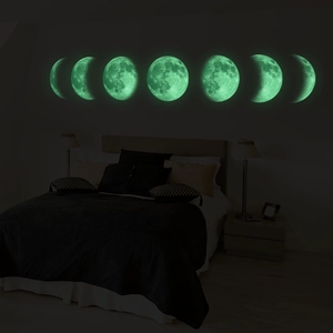 Luminous moon phase wall stickers glowing in green for creative bedroom home decor