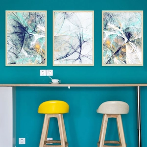 Three-piece abstract Nordic art prints with light wood frames on dark teal wall