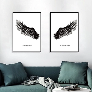 Detail of minimalist black wing wall art with A Broken Wing text in a modern living room