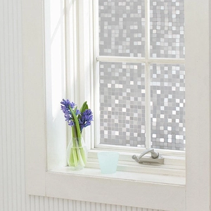 Detailed view of mosaic window privacy film on a glass pane with soft indoor lighting