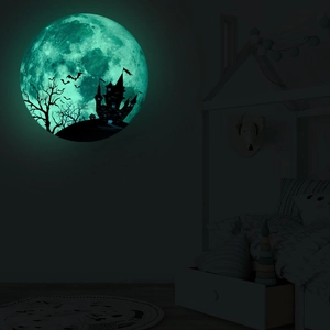 Close-up of glowing moon wall sticker with castle and bat silhouettes for Halloween
