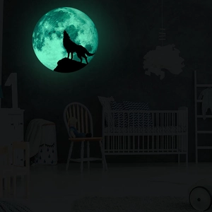 Luminous moon wall sticker featuring a howling wolf silhouette in a dark bedroom