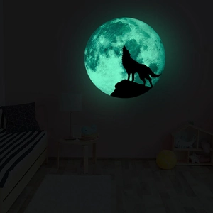 Glow-in-the-dark full moon and howling wolf wall sticker in a dark bedroom scene