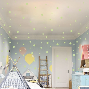 Luminous wall stickers with dots and balloons glowing in a cozy child bedroom setting