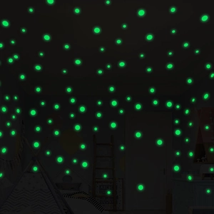 Detailed view of luminous green circular wall stickers glowing in a dark bedroom