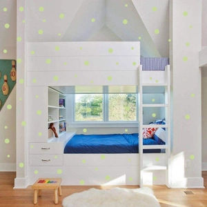 Detailed view of luminous green polka dot wall stickers in a modern bedroom setting