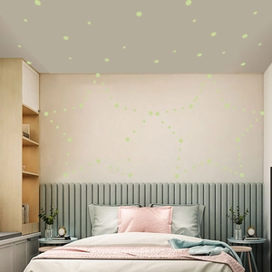 Luminous green dot wall stickers forming a creative star pattern on a cozy bedroom ceiling