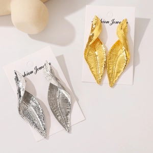 Exaggerated metal leaf earrings in gold and silver finish with textured surface