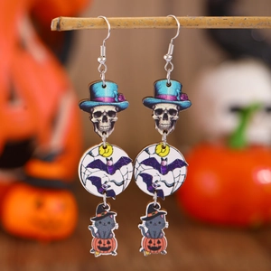 Detailed close-up of Halloween wooden drop earrings hanging on branches with pumpkin decor