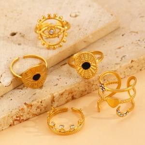 Detail view of five gold-toned adjustable rings with evil eye, star, and moon motifs