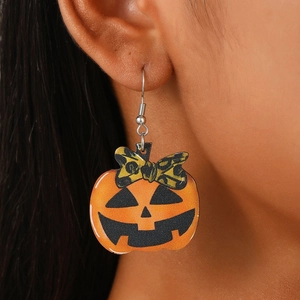 Detail view of Halloween pumpkin earrings with leopard bow worn on the ear