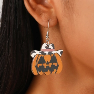 Close-up of wooden Halloween pumpkin earrings with cow print hat on a model ear