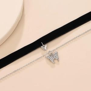 Dettaglio del choker in velluto e catena con pendenti a farfalla in strass scintillanti