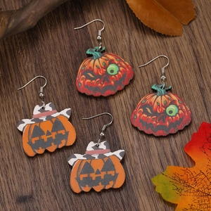 Halloween wooden pumpkin earrings with cowboy hats and zombie eyes on dark wood background