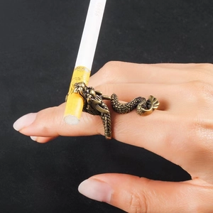 Detail eines bronzenen Zigarettenhalters in Drachenform am Finger getragen