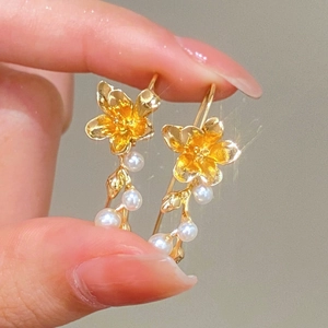Matgouden bloem oorbellen met witte parels in een elegant en bloemig ontwerp