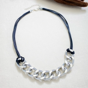 Collar estilo industrial con cadena plateada gruesa y cordón negro de diseño moderno