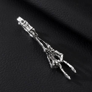 Nahaufnahme eines silbernen Skeletthand-Rings mit Friedenszeichen auf schwarzem Leder