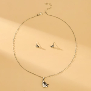 Conjunto de joyas de plata pulida con collar de niña abrazando a un perro y pendientes