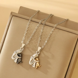 Detalle de collares con colgante de niña y perro en plata y oro sobre joyero