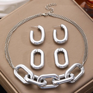 Conjunto de collar de cadena gruesa plateada y pendientes ovales sobre cuero marrón