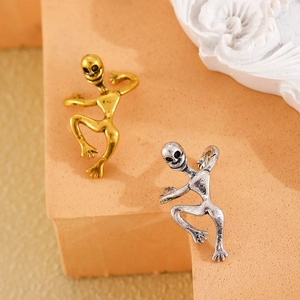 Detail of creative alien climbing ear clips in vintage gold and antique silver metal finish