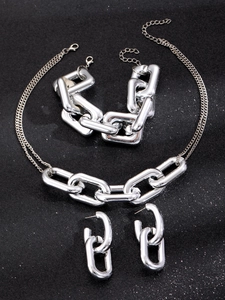 Conjunto de joyas de cadena gruesa plateada con collar y pulsera sobre fondo negro brillante