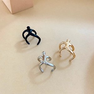 Detail shot of minimalist climbing human figure ear cuffs in silver, gold, and black colors