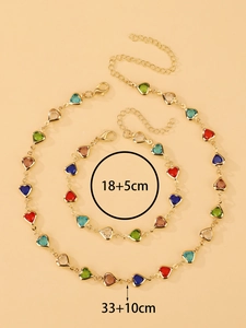Detalle de conjunto de collar y pulsera con gemas de corazón coloridas y medidas en dorado
