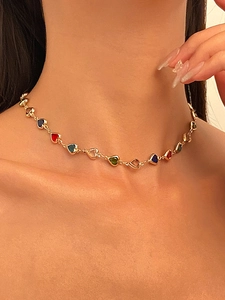 Gros plan d'un collier en Y doré avec des pendentifs en cristal coloré en forme de cœur