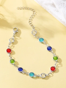 Detalle de pulsera de cadena plateada con gemas redondas de colores y cierre de langosta