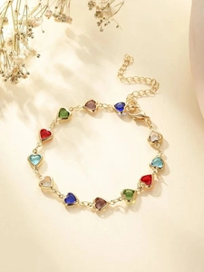 Detalle de una pulsera dorada con dijes de corazones coloridos y cierre de mosquetón