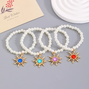 Set of four pearl bracelets with vintage sun charms featuring colorful gemstones